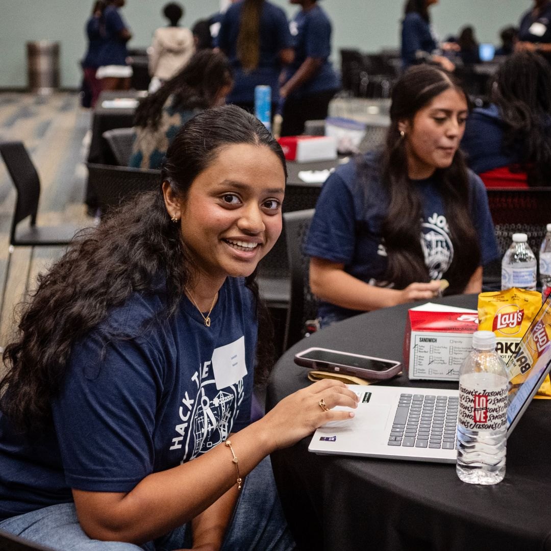 Lakshitha working on a laptop at the Hack the Jobsite hackathon